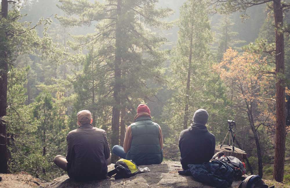group of young men resting during hike in forest