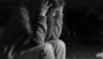 addicted to Demerol, Addiction to Demerol, Abuse of Demerol, upset woman seen through glass with rain on it - black and white