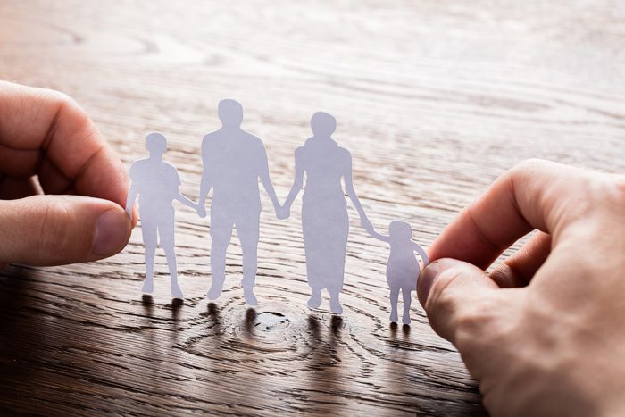 Intervention; systemic intervention, hands holding white paper cutout of family