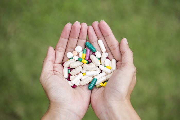 hands holding variety of pills