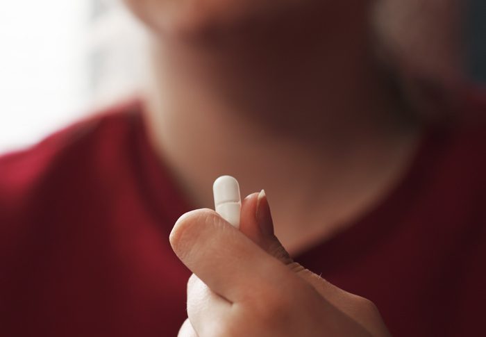 closeup of teen holding pill