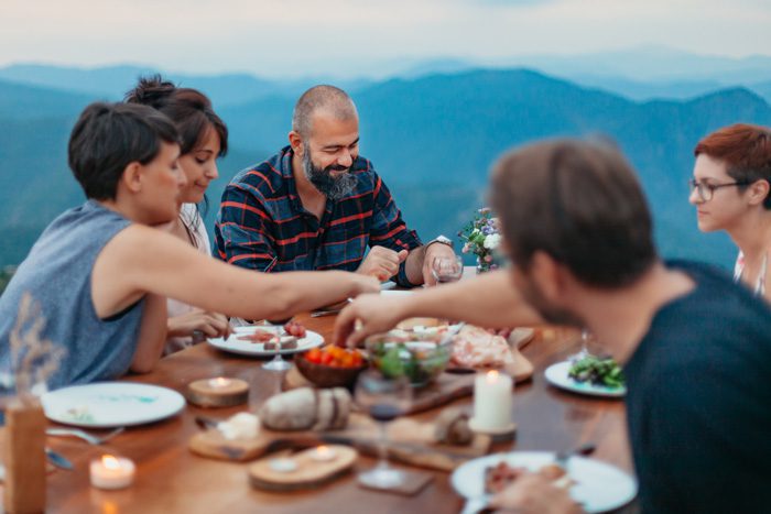 friends gathered for outdoor Thanksgiving or Christmas meal together - stressful