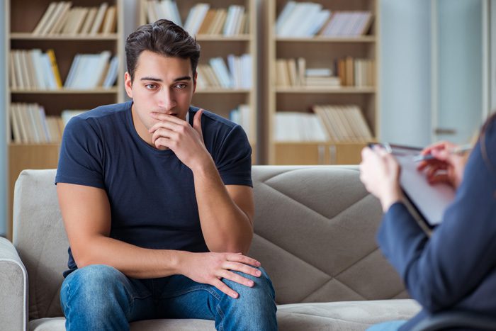 What Is Cognitive Behavioral Therapy?, young man in therapy session with counselor - CBT