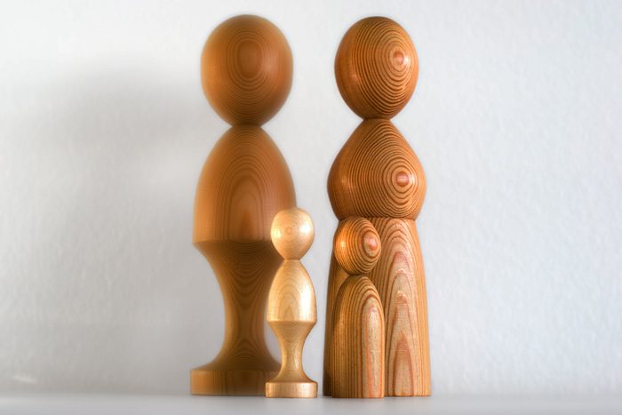 four wooden figurines on white background - family therapy