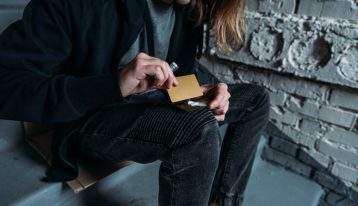 long haired man cutting lines of cocaine on a credit card - cocaine addiction