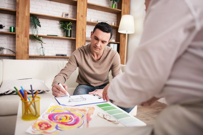 man doing art therapy in therapist's office - residential addiction treatment