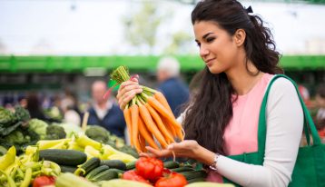 Nutrition and Exercise in Addiction Recovery, Nutrition and Addiction Recovery, Nutrition, beautiful Latina woman holding a bunch of carrots in the produce section of a grocery store - exercise